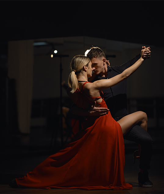 Experienced dancers performing a complex rumba move, showcasing advanced technique. (Master your rumba with advanced technique classes at JT Dance Studio.)