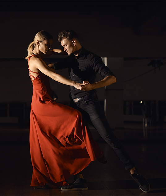 A couple receiving private rumba instruction from a professional dance teacher. Take your rumba dancing to new heights with private lessons at JT Dance Studio.